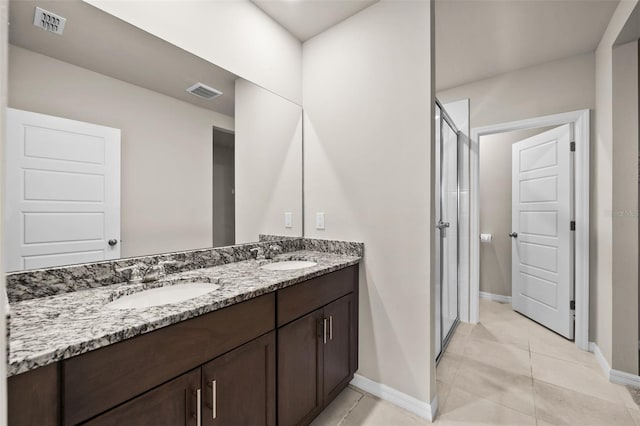 bathroom with tile patterned floors, a shower with door, and vanity