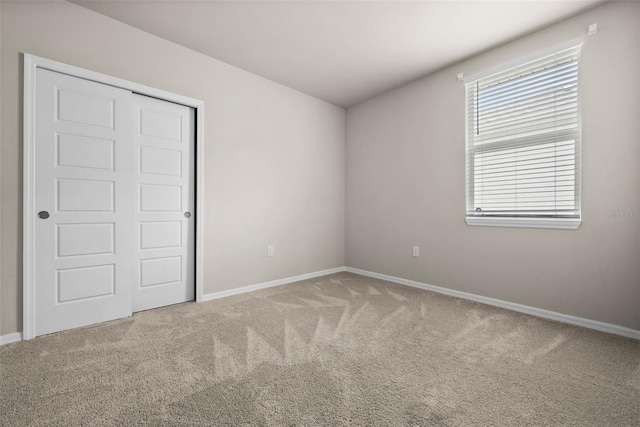 unfurnished bedroom with a closet and carpet flooring