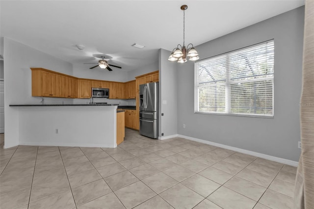 kitchen featuring kitchen peninsula, appliances with stainless steel finishes, light tile patterned flooring, and ceiling fan with notable chandelier