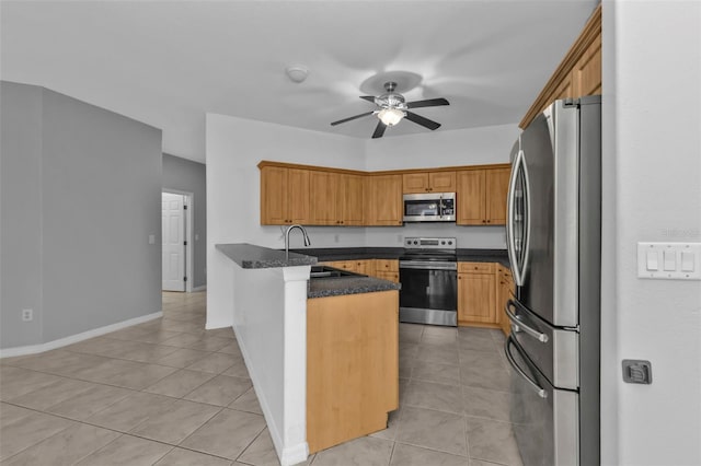 kitchen with ceiling fan, kitchen peninsula, sink, light tile patterned flooring, and stainless steel appliances