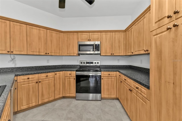 kitchen featuring ceiling fan, light tile patterned floors, and stainless steel appliances