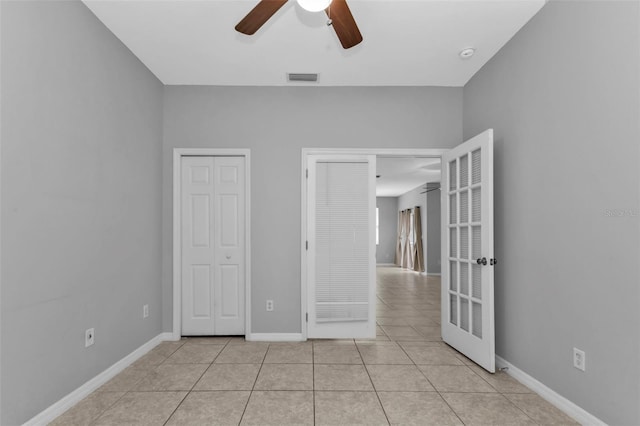 unfurnished bedroom with ceiling fan and light tile patterned floors