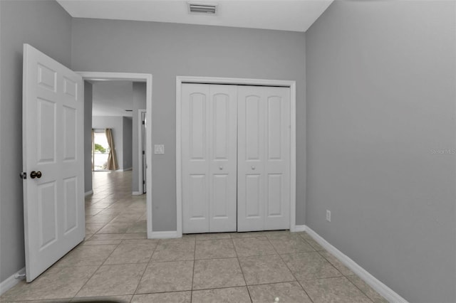 unfurnished bedroom with light tile patterned floors and a closet