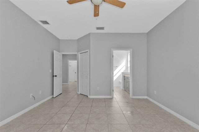 unfurnished bedroom with ceiling fan, ensuite bath, a closet, and light tile patterned flooring