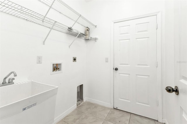 washroom with light tile patterned floors, sink, hookup for a washing machine, and electric dryer hookup