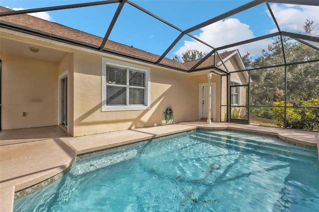 back of house with glass enclosure and a patio