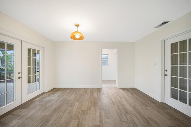 spare room with french doors and light wood-type flooring