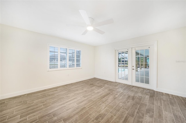 spare room featuring ceiling fan, a wealth of natural light, light hardwood / wood-style floors, and french doors