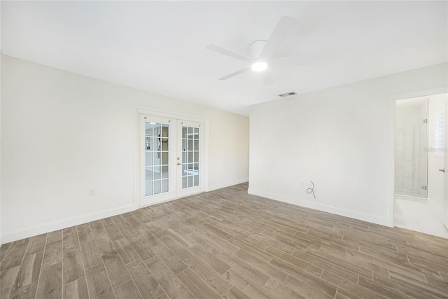 empty room with ceiling fan, light hardwood / wood-style floors, and french doors