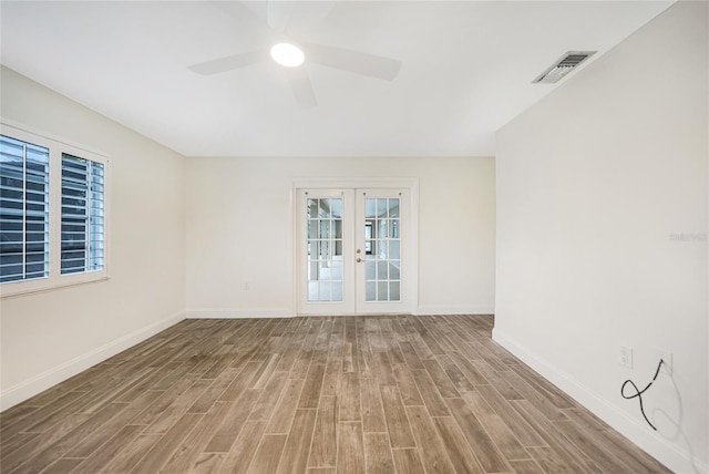 unfurnished room featuring hardwood / wood-style flooring, ceiling fan, and french doors