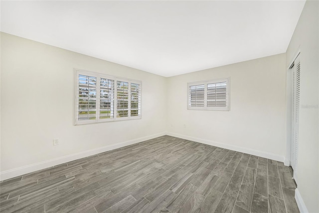 unfurnished room featuring dark wood-type flooring and plenty of natural light