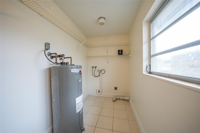 laundry area featuring electric dryer hookup, light tile patterned floors, and water heater