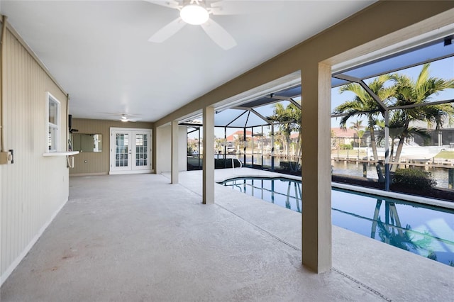 view of swimming pool with french doors, a patio area, a water view, a lanai, and ceiling fan