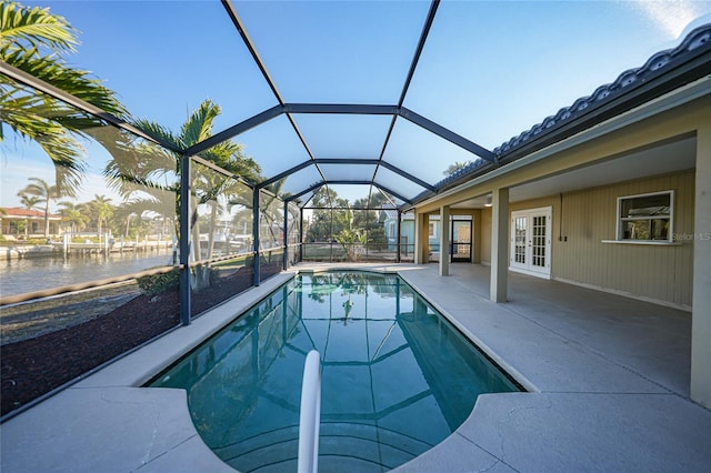 view of swimming pool featuring french doors, a water view, a lanai, and a patio area