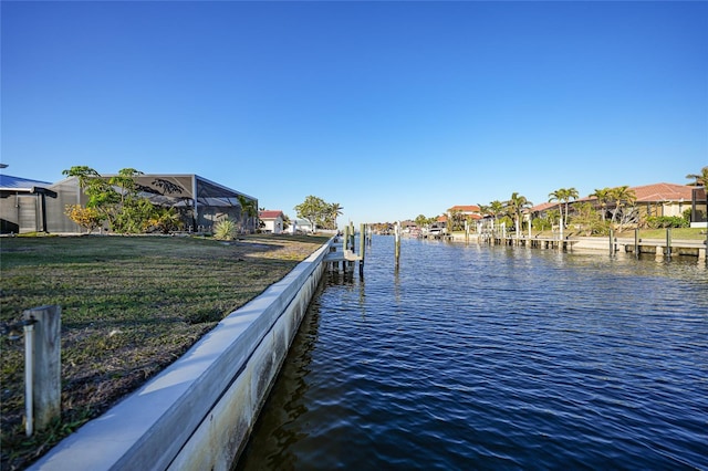 view of dock with a lawn and a water view