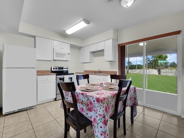 dining area featuring sink and light tile patterned floors