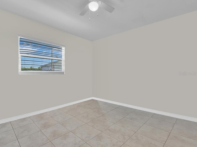 tiled spare room featuring ceiling fan