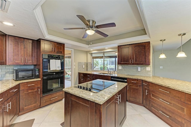 kitchen featuring light stone counters, backsplash, black appliances, and a raised ceiling