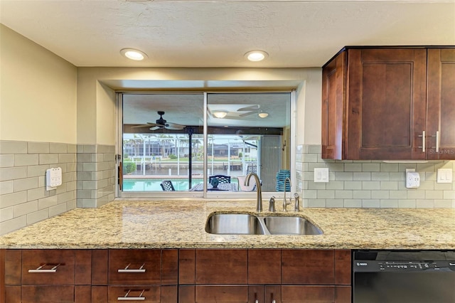 kitchen with sink, dishwasher, ceiling fan, backsplash, and light stone counters