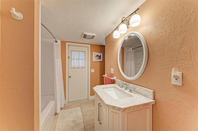 bathroom with vanity, tile patterned flooring, a textured ceiling, and shower / bath combo with shower curtain