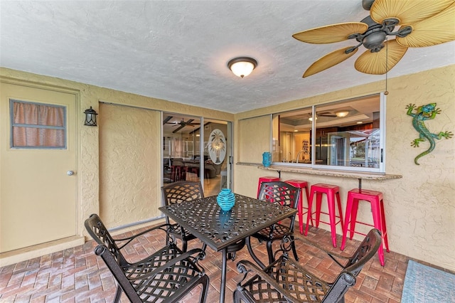 dining room featuring ceiling fan and a textured ceiling