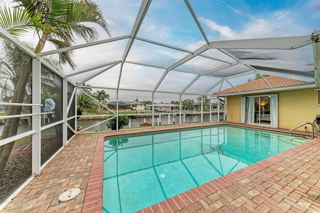 view of swimming pool with a lanai and a water view