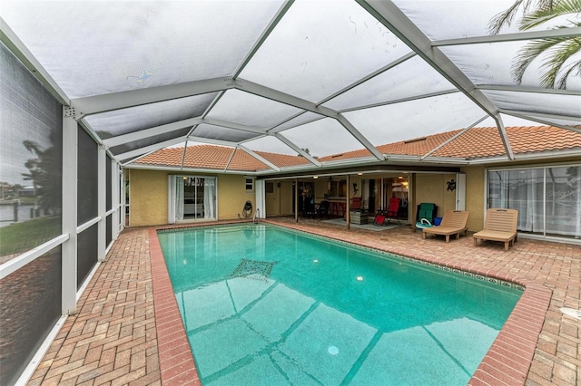 view of swimming pool with a patio and glass enclosure