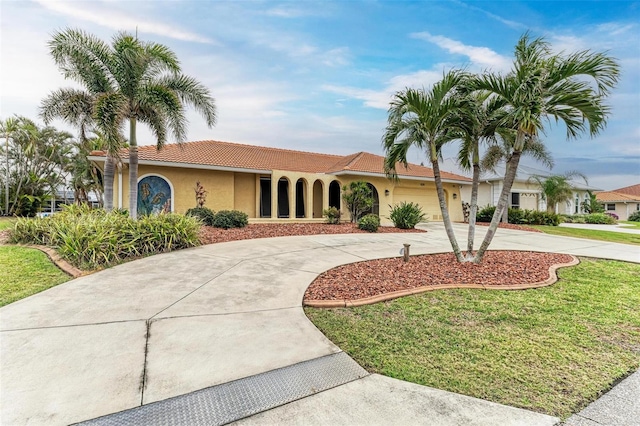 mediterranean / spanish-style home with a garage and a front lawn