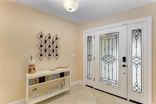 foyer entrance featuring light tile patterned floors and a textured ceiling