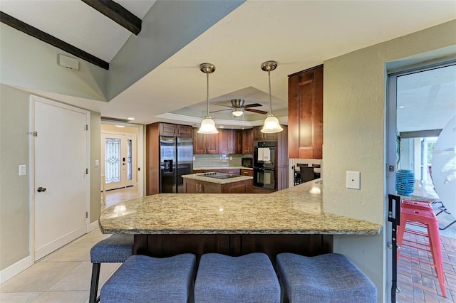 kitchen featuring beamed ceiling, black appliances, a kitchen bar, hanging light fixtures, and kitchen peninsula