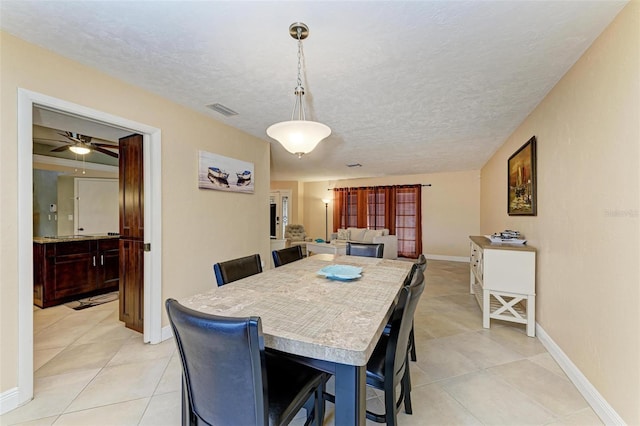 dining room featuring light tile patterned floors and a textured ceiling