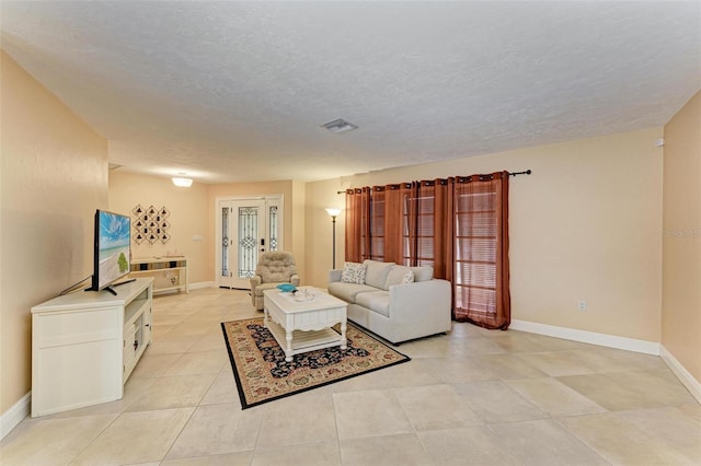 living room featuring light tile patterned flooring and a textured ceiling