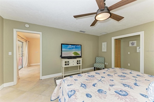 tiled bedroom with a textured ceiling and ceiling fan