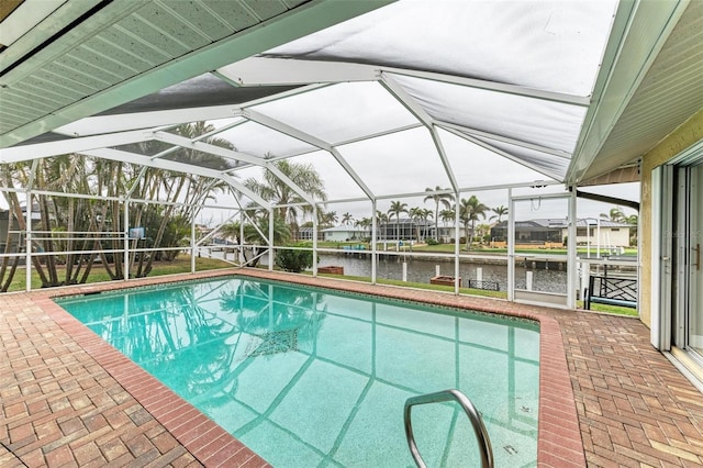 view of swimming pool with a water view, a patio area, and glass enclosure