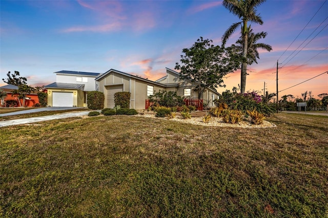 view of front of home with a lawn and a garage