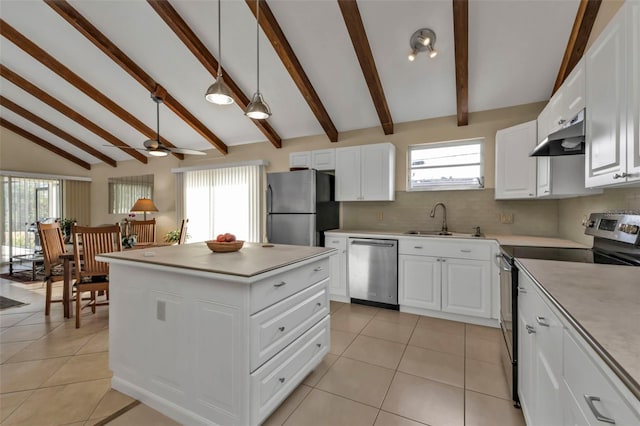 kitchen with pendant lighting, appliances with stainless steel finishes, white cabinetry, vaulted ceiling with beams, and sink