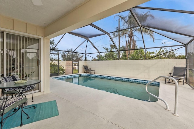 view of swimming pool with glass enclosure and a patio area