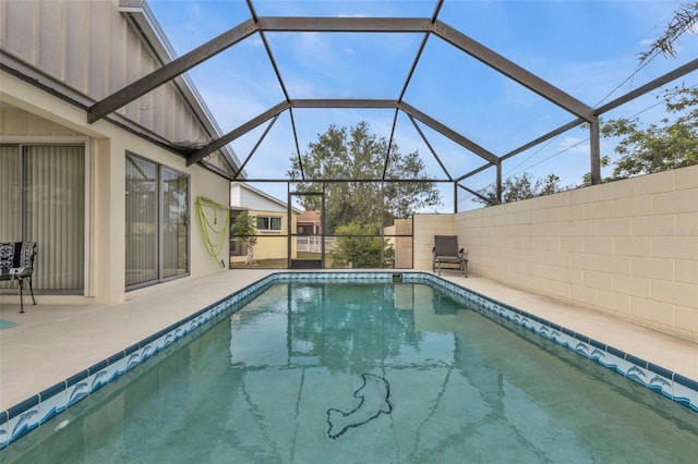 view of swimming pool featuring glass enclosure and a patio area