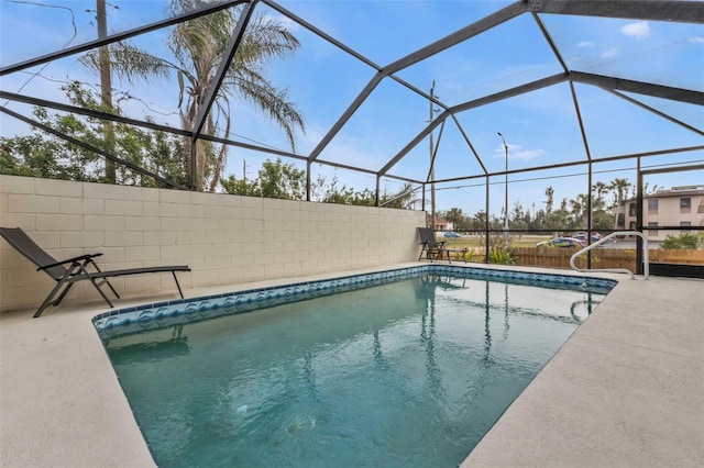 view of pool with glass enclosure and a patio area