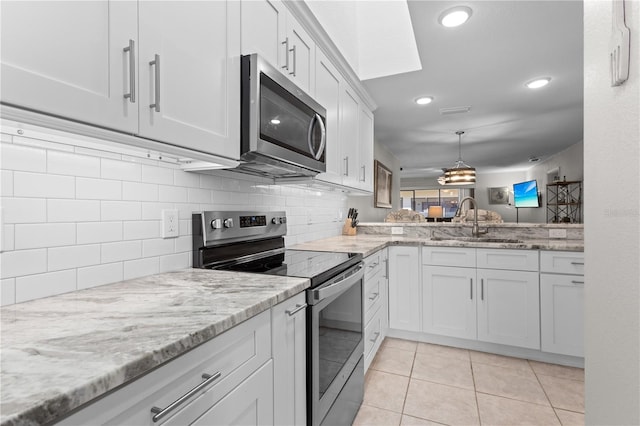 kitchen featuring sink, tasteful backsplash, light tile patterned floors, stainless steel appliances, and white cabinets