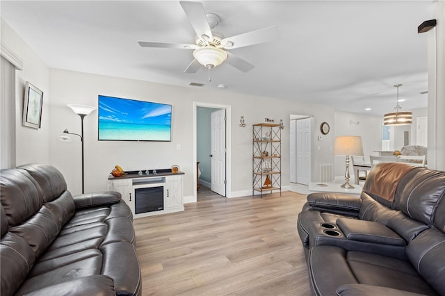 living room featuring ceiling fan and light wood-type flooring