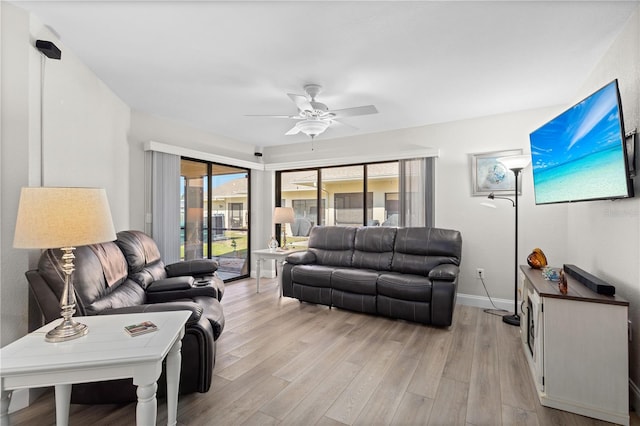 living room with light hardwood / wood-style flooring and ceiling fan