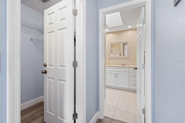 corridor with sink and light tile patterned floors