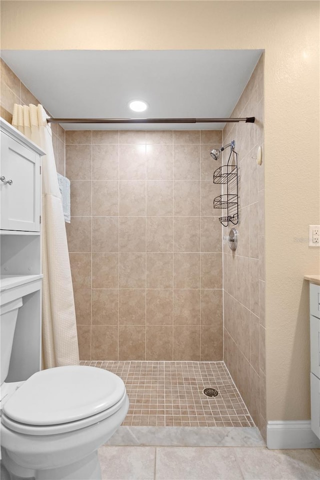 bathroom with vanity, a tile shower, tile patterned floors, and toilet