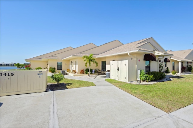 single story home featuring cooling unit and a front yard