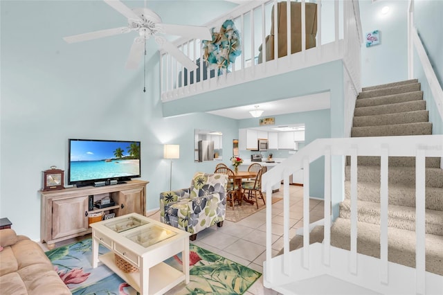 living room featuring light tile patterned floors, a towering ceiling, and ceiling fan