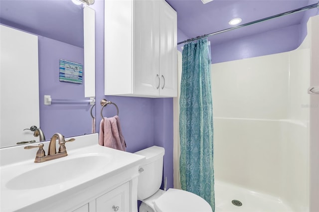 bathroom featuring vanity, curtained shower, and toilet