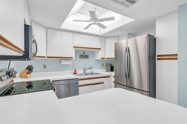 kitchen with stainless steel appliances, white cabinetry, sink, and ceiling fan