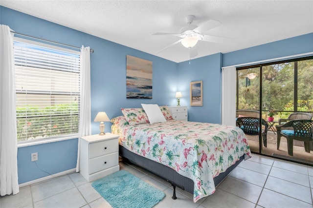 tiled bedroom with ceiling fan, access to exterior, and a textured ceiling