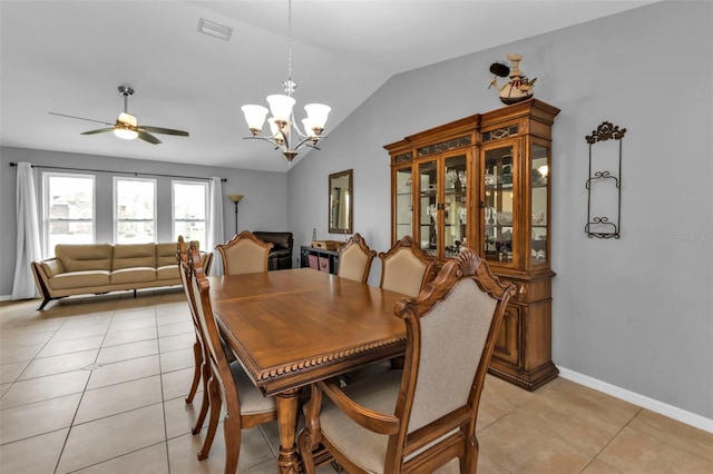 tiled dining room featuring ceiling fan with notable chandelier and vaulted ceiling